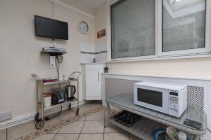 a living room with a microwave on a table at Cozy Barnhill Annex in Manchester