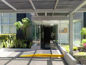 an entrance to a building with glass doors and plants at Apartment - 2Bedrooms - QueenBed - Balcony - Parking - 7thFLOOR in Quito