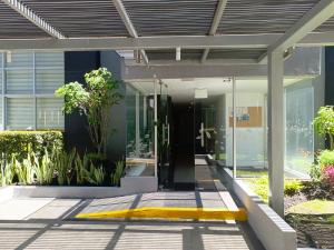 an entrance to a building with glass doors and plants at Downtown Quito - Balcony - Gym - Parking - 7thFLOOR in Quito