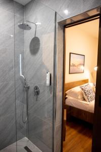 a shower with a glass door in a bedroom at Terra'Vista Apartments in Tirana