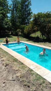 a group of children playing in a swimming pool at Hospedaje Finca La Siciliana in San Martín