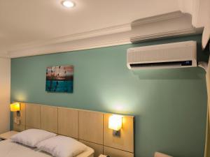 1 Schlafzimmer mit einem Bett und Klimaanlage in der Unterkunft Barra Prime Flats, Ed Mediterrâneo, wi-fi 400Mb, balsa pra praia grátis, ar condicionado novo! in Rio de Janeiro