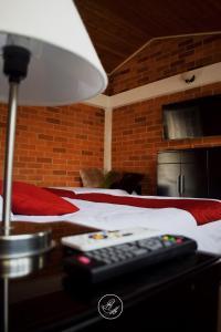 a remote control sitting on a table next to a bed at Hotel Boutique Rosa María in Iza