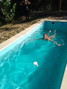 a woman in a swimming pool with a frisbee at Hospedaje Finca La Siciliana in San Martín