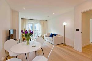 una sala de estar con un jarrón de flores sobre una mesa en Westwood Brand new AC Luxury 2bed 2 bathrooms spacious family unit, en Londres