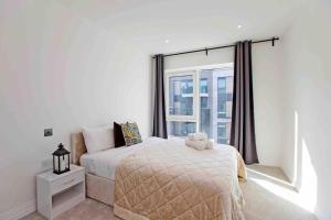 um quarto com uma cama e uma grande janela em Westwood Brand new AC Luxury 2bed 2 bathrooms spacious family unit em Londres