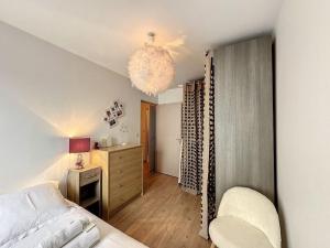 a bedroom with a bed and a chandelier at Cosy appt, Secteur vaise Mars 1 in Lyon