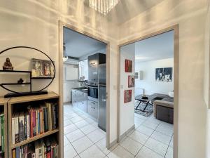 a living room with a book shelf and a kitchen at Cosy appt, Secteur vaise Mars 1 in Lyon