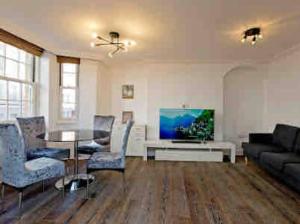 ein Wohnzimmer mit einem Tisch und einem Sofa in der Unterkunft Fitzrovia 2 Bed modern +Lift central London in London