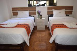 1 Schlafzimmer mit 2 Betten und einem Spiegel in der Unterkunft HOTEL VALLE DORADO MACHUPICCHU in Machu Picchu