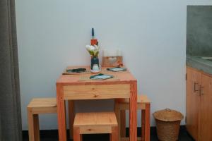 a small wooden table with a vase of flowers on it at Charming dark lodge in river in Weligama