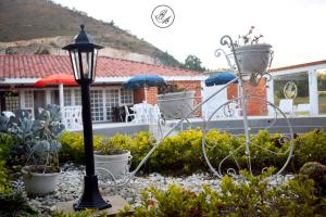 una luz de la calle en un jardín con plantas y una casa en Hotel Boutique Rosa María, en Iza