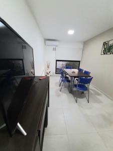 a conference room with a table and blue chairs at Departamento FICO 2 in Sunchales