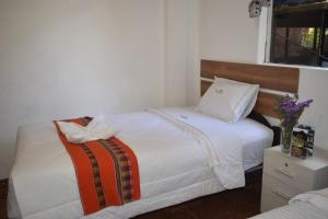 1 dormitorio con cama blanca con arco en HOTEL VALLE DORADO MACHUPICCHU, en Machu Picchu