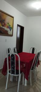 a dining room table with a red table cloth and chairs at Chalés Pôr Do Sol in Caparaó Velho