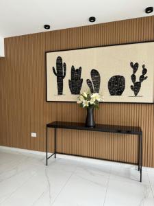 a table with a vase of flowers on a wall at Guemes Hotel & Spa in Salta