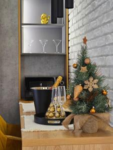 a table with a christmas tree next to a fireplace at Akis CityChic Apartment in Cluj-Napoca