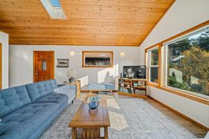 a living room with a blue couch and a wooden ceiling at Sand Bucket in Manzanita