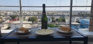 薩利納斯的住宿－Jade Aparts Salinas，一张桌子,上面放着一瓶葡萄酒和两份三明治