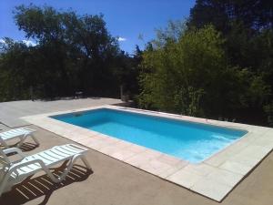 una piscina con 2 sillas de jardín y un par en Las Moras en Villa Giardino
