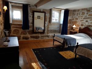 a bedroom with a bed and a mirror on the wall at Solar dos Pedrosos in Vila Chã +4 photos