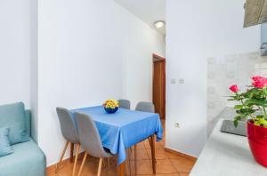 a dining room with a blue table and chairs at Apartments by the sea Fazana - 6957 in Marana