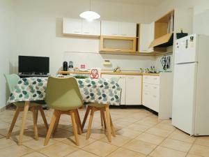 uma cozinha com uma mesa e cadeiras e um frigorífico branco em BeBAdamo ed Eva em Villaggio del Fanciullo