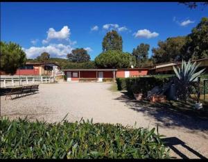 um pátio com um edifício vermelho e uma cerca branca em BeBAdamo ed Eva em Villaggio del Fanciullo