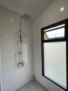 a shower in a bathroom with a window at Punpawn ปั๋นปอนด์ Farm Stay in Chiang Saen