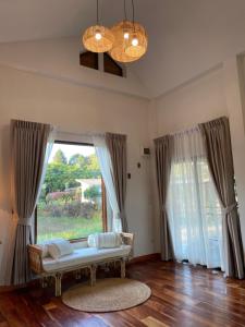 a living room with a couch in front of a window at Punpawn ปั๋นปอนด์ Farm Stay in Chiang Saen