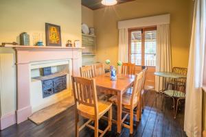 a dining room with a table and a fireplace at St Bernards Presbytery- Hartley Historic Site in Hartley