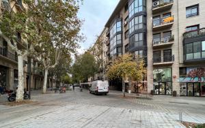 uma rua da cidade com uma carrinha branca estacionada em frente aos edifícios em Stay Unique Apartments Cent em Barcelona