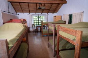 a room with several bunk beds and a table at La María Paloma in Capitán Sarmiento