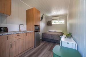 uma pequena cozinha com uma cama numa pequena casa em Gundagai Tourist Suites em Gundagai