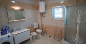 ein Bad mit einer Dusche, einem WC und einem Waschbecken in der Unterkunft Family friendly apartments with a swimming pool Vinisce, Trogir - 12676 in Vinišće
