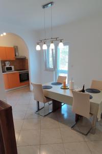 a kitchen and dining room with a table and chairs at Family friendly apartments with a swimming pool Vinisce, Trogir - 12676 in Vinišće