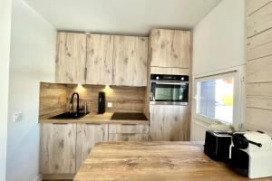 una cocina con armarios de madera y fregadero en Bright apartment - close to the slopes, en Demi-Quartier