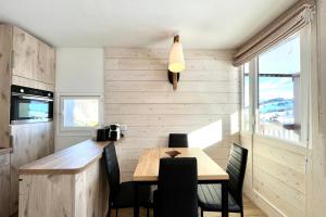comedor con mesa de madera y sillas en Bright apartment - close to the slopes, en Demi-Quartier