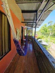 eine Veranda mit Hängematte auf einem Haus in der Unterkunft Casa luna in Puerto Viejo