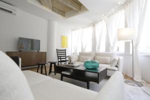 a white living room with a couch and a table at Apartments Angel Just 50 m from Zagreb Main Square in Zagreb