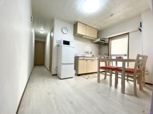 a kitchen with a table and a white refrigerator at Ueno正和ビル in Tokyo