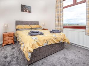 1 dormitorio con cama y ventana en Auld House, en Brora