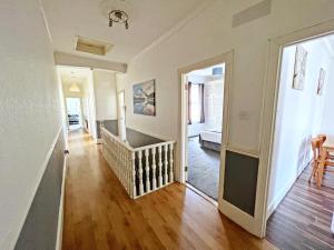 Beautiful 3 bed apartment - Free parking, Near trains في Norbury: غرفة معيشة بها درج وغرفة بها ممر