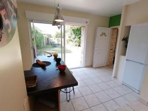 a kitchen with a table and a door to a yard at Gîte Cossé-le-Vivien, 4 pièces, 6 personnes - FR-1-600-143 in Cossé-le-Vivien