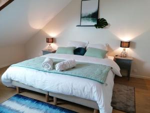 a bedroom with a large white bed with two lamps at Gîte Cossé-le-Vivien, 4 pièces, 6 personnes - FR-1-600-143 in Cossé-le-Vivien