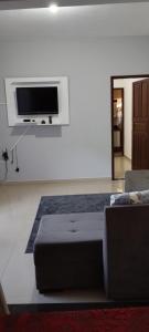 sala de estar con cama y TV de pantalla plana en Chalés Pôr Do Sol, en Caparaó Velho
