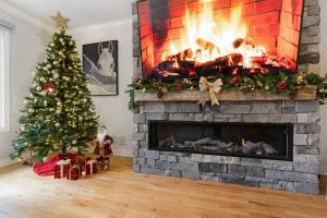 a living room with a christmas tree and a fireplace at Charming riverside cottage, walk to beach in Wasaga Beach