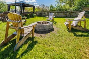 three chairs and a fire pit in a yard at Charming riverside cottage, walk to beach in Wasaga Beach