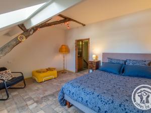 een slaapkamer met een blauw bed en een stoel bij Gîte Ingrandes-Le Fresne sur Loire, 5 pièces, 8 personnes - FR-1-622-38 in Ingrandes