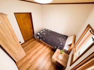 a small room with a bed and a door at KONAYUKI in Myoko